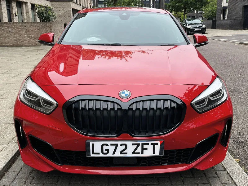 Front view of a red BMW 1 Series M Sport, showing the black kidney grille, LED headlights and white UK registration plate “LG72 ZFT.”