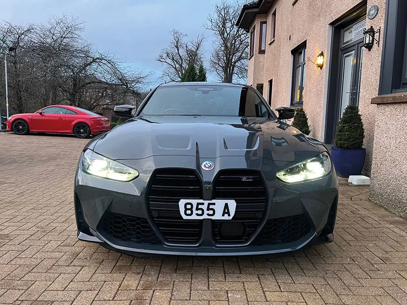 Front view of a grey BMW M3 G80 fitted with a short white Signature number plate displaying “855 A,” positioned across the kidney grille.