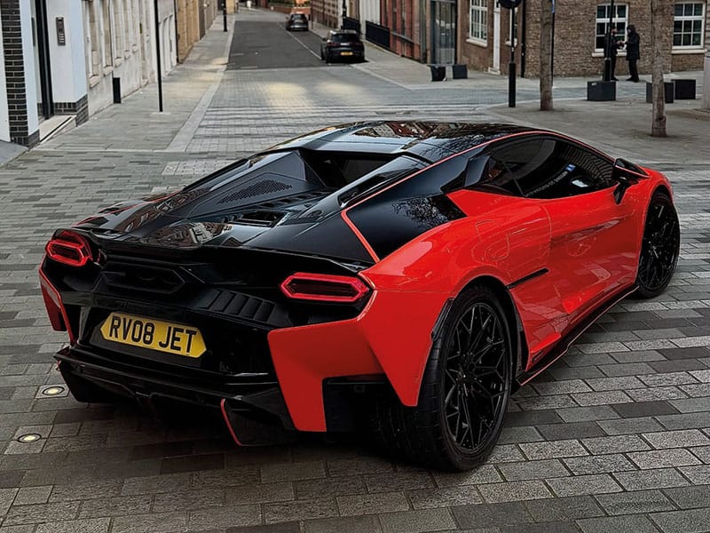 Rear three-quarter view of a red Lamborghini Temerario, showing its angular LED taillights, black rear detailing and yellow shaped number plate displaying “RV08 JET.”
