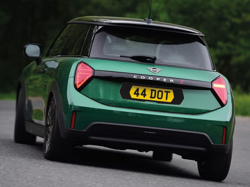 Rear view of a green MINI Cooper S featuring a yellow 44 DOT number plate with a black surround.